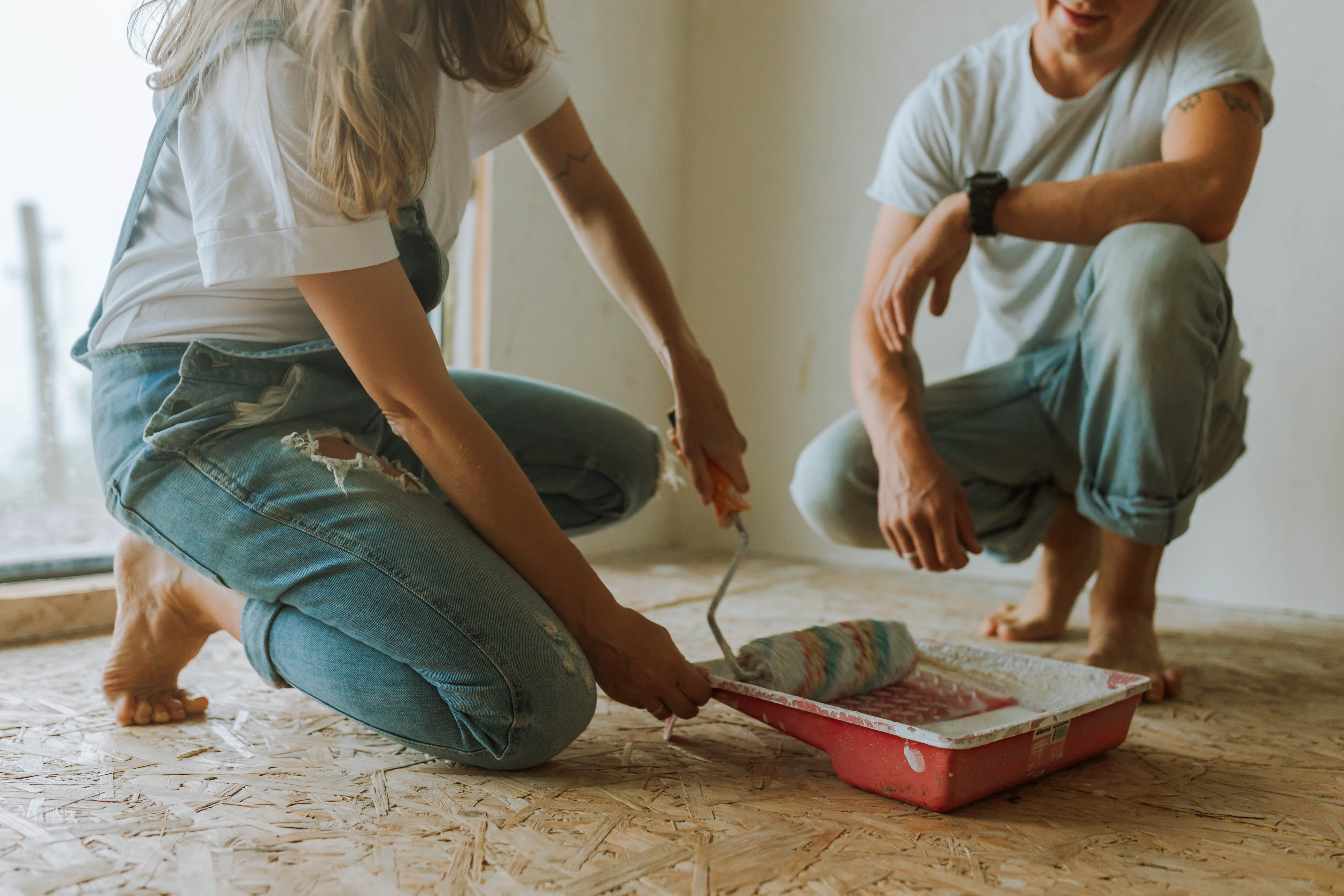 Couple working on paint and flooring together, close-up.